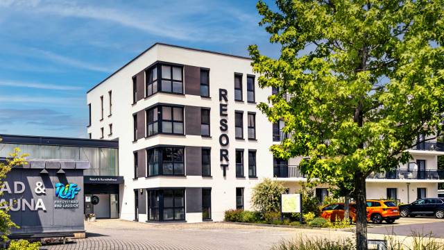 Eingang zur Resort vom Parkplatz aus mit saftig grünem Baum