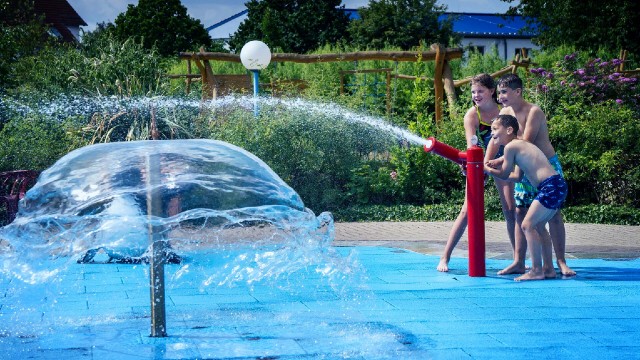 Kinder an der Wasserspritze im Freibereich des Freizeitbad RIFF Bad Lausick