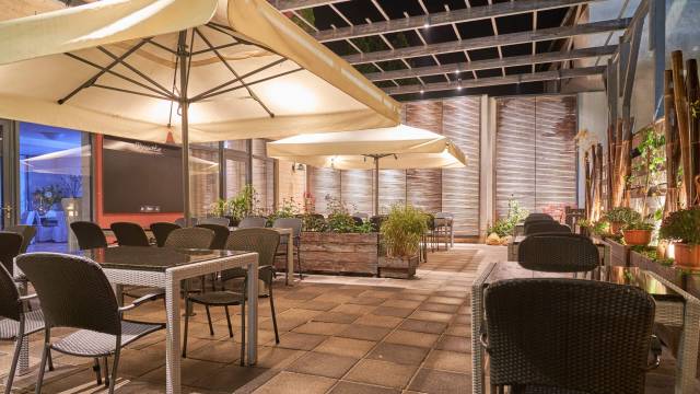 Gemütliche Terrasse des Restaurants „Dynastie“ in Bad Lausick mit Sonnenschirmen.