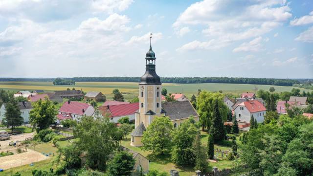 Luftaufnahme, im Zentrum des Bildes die Kirche des Ortsteil
