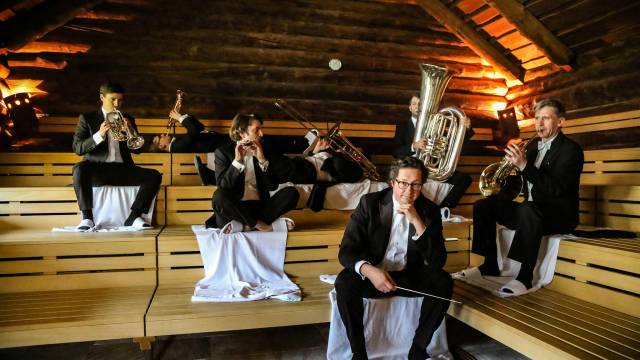 Dirigent und Musiker mit Blasinstrumenten in der Sauna