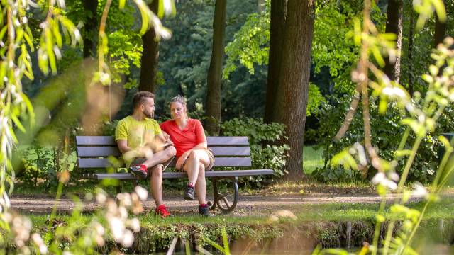 Kurgäste sitzend auf einer Parkbank im Kurpark Bad Lausick