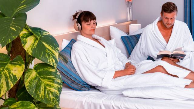 Mann und Frau im Bademantel auf einem Bett im RIFF Resort